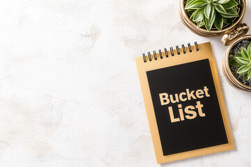 2025 bucket list concept. Notebook with "Bucket List" on a desk with potted plants nearby