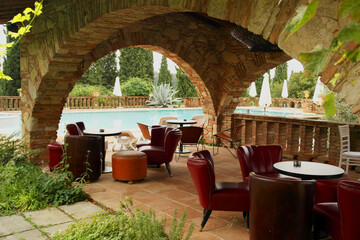 View of a relaxation area with tables, armchairs and swimming pool