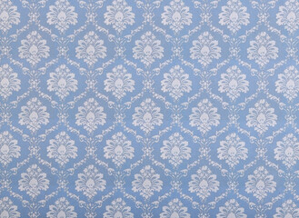Old wallpaper on the wall. Old wallpaper for texture or background.