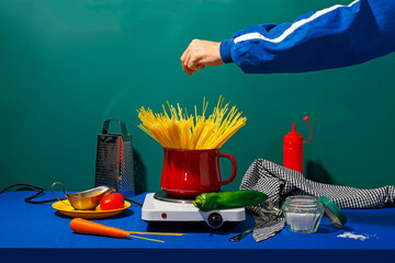 Hand of man adding salt in spaghetti