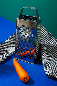 Food slicer and carrot on table with gingham tablecloth in studio