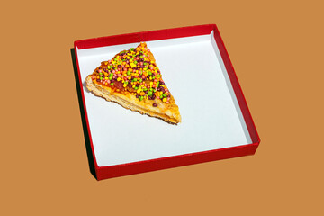 Still life of a sweet candy pizza slice in a box