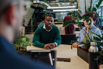 Confident businessman leading meeting in modern green office