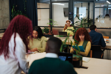 Diverse team collaborating in modern green office space