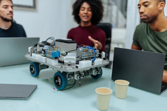 Engineers collaborating on a robotics project, building and programming a robot prototype