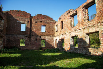 Interior of an old brick building, trees visible outside