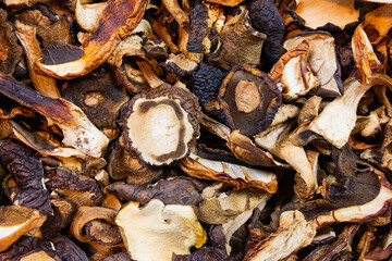 Dried mushrooms, bay boletes and porcini mushrooms spilled on the table. Close-up.
