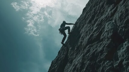 Obraz premium Determined Climber Scaling Steep Mountain Face Against Dramatic Sky and Rocky Terrain