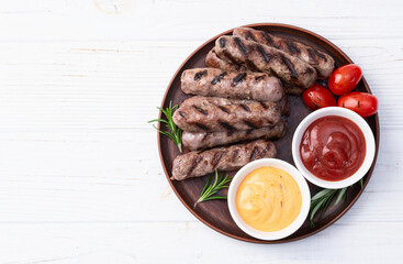 Grilled beef sausages with rosemary sauce and tomatoes photography . Top view