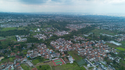 Aerial View of Green Hilly Highlands with Local Houses Facing Bandung City in Indonesia