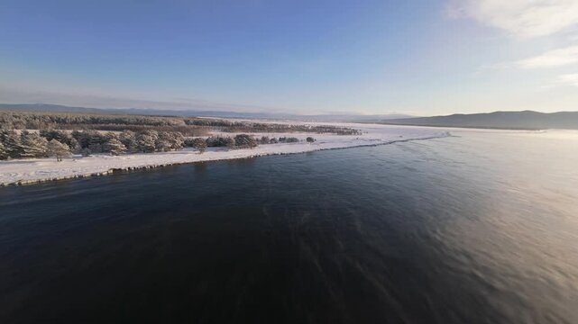 Beautiful fpv drone areial view of winter Baikal lake winter freezing lake baikal, with water, but already beginning to freeze, November
