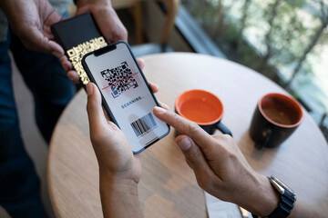 Customer paying with qr code on smartphone screen NFC payment technology at coffee cafe.