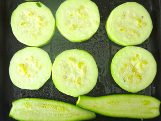 Courgettes cut into slices and placed on a baking sheet for frying