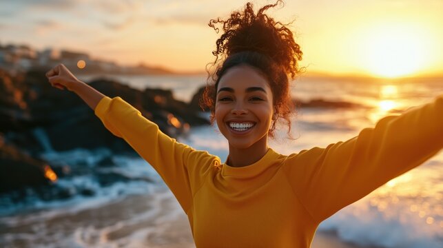 Frau mit ausgebreiteten Armen am Strand bei Sonnenuntergang