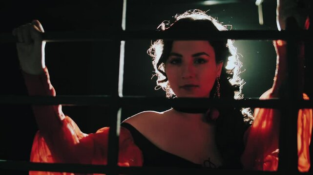 Beautiful brunette girl behind bars. The gypsy is a fraud. Temptation. Hypnosis. Women's prison. A woman is in captivity.