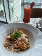 Seafood Pasta;Delicious Italian tagliatelle pasta with rich tomato sauce and creamy burrata cheese topped with olive oil and black pepper in a white ceramic bowl