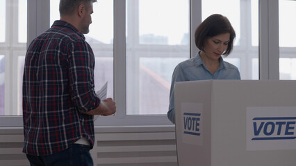 Man holds a ballot paper as he walks to the voting booth, ready to make his decision responsibly