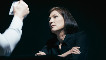 Drug investigator shows evidence in a bag to a female suspect, who denies her guilt