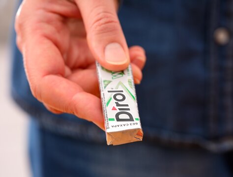 Tambov, Russian Federation - December 20, 2023 Woman hand giving pack of Dirol chewing gum.