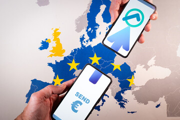 Smartphone screens displaying euro symbol and transfer icon over map of Europe, symbolizing The...