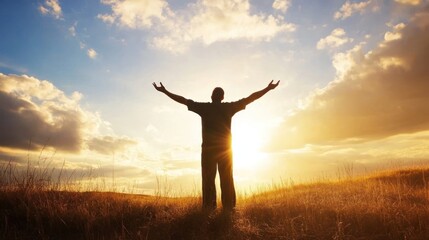 Person with open arms stands before a setting sun