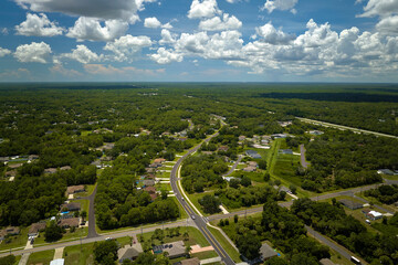 Aerial view of street traffic with driving cars in small town. American suburban landscape with private homes between green palm trees in Florida quiet residential area