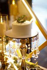 Sweet wedding table, there is a lot of delicious food on it, the cake is in the middle, and there is a lot of sweets around.