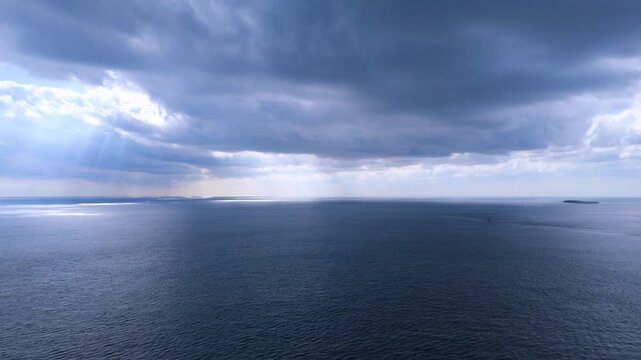 The mysteriousness of the sun shining through clouds from the sky, the sea, and Songaksan Dulle-gil, Jeju Island, Korea