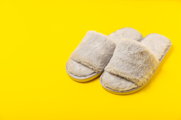 Soft slippers on a bright colored background, close-up. House slippers. Comfortable shoes for home. Foot care concept. Home comfort. Space for text. Copy space.