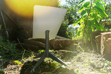 Low-angle view of a satellite internet antenna positioned in a garden, optimized to catch signals...