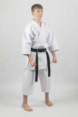 Fifteen year old male teenage karate black belt standing in Ready Stance, studio shot against a...