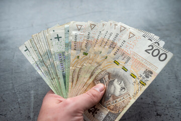 male holds polish zloty banknotes money for payment