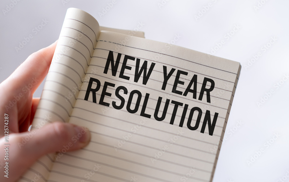 Poster text new year resolutions on note in hand, office desk with computer