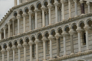 Pisa Cathedral. White marble facade of the cathedral.Pisan Romanesque style arcades with columns and arches. Italy