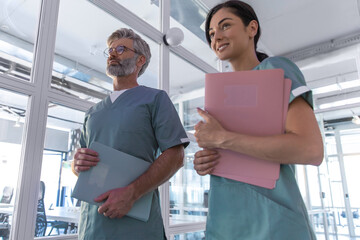 Two colleagues doctors in lab coats with prescription lists in hands