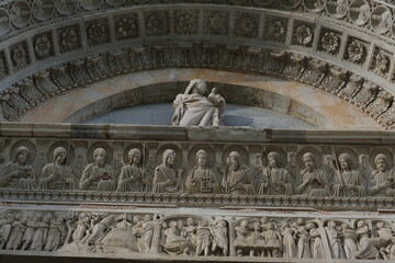 Madonna with child. Decorations on marble facades. Detail of the baptistery and the cathedral of Pisa with decorations in Romanesque style. Italy