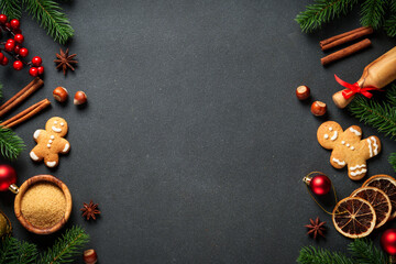 Christmas baking ingredients at black. Gingerbread cookies, spices and Christmas decorations. Flat lay with space for text.