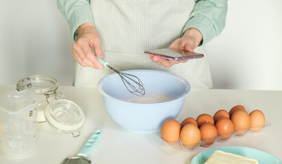 Person baking using mobile app for finding the recipe