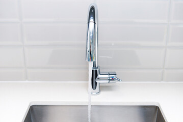 water flows from stainless steel kitchen faucet