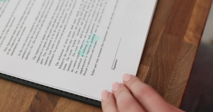 Woman puts stamp Approved on business document validating content. Female presses stamp on file confirming authenticity and legal validity