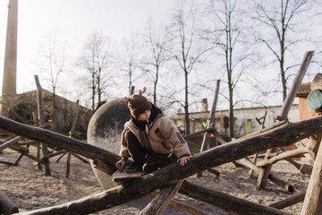 Cute girl, preschooler female kid playing, sliding in kid wooden playground, concept image for...