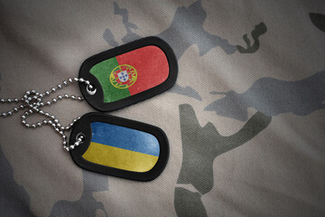 vintage army blank, dog tag with flag of portugal and ukraine on the khaki texture background....