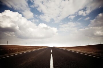 Empty Highway Under Cloudy Blue Sky in Countryside Setting
