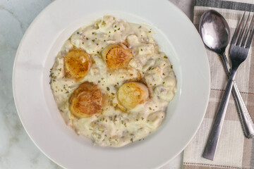 clam chowder top  with herbs and scallops