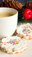 Cup of coffee with delicious homemade Christmas cookies on the table with decorative Christmas background.
