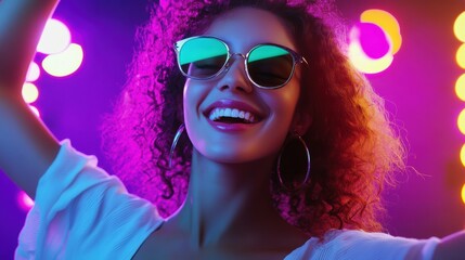 Young woman with curly hair and sunglasses enjoying the vibrant lights at a party.