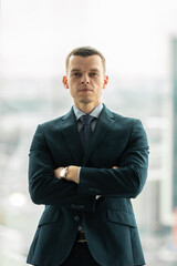 Successful smiling ambitious caucasian european businessman lawyer in suit standing in light office with laptop and phone