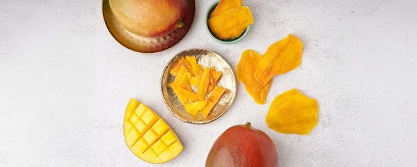 Fresh and dried mango on light background, top view