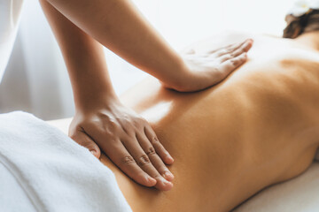 Fototapeta premium Closeup woman customer enjoying relaxing anti-stress spa massage and pampering with beauty skin recreation leisure in day light ambient salon spa at luxury resort or hotel. Quiescent