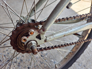 close-up view of a bicycle rusty chainring, chain, and rear wheel. 